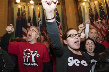 Labor union members and supporters demonstrate in opposition to a proposed right-to-work measure inside the capitol building in Lansing, Michigan in this December 11, 2012, file photo. REUTERS/James Fassinger/Files