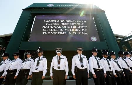 Police officers observe a national minute's silence for victim's of the attacks in Tunisia a week ago at the Wimbledon Tennis Championships in London, July 3, 2015. REUTERS/Suzanne Plunkett