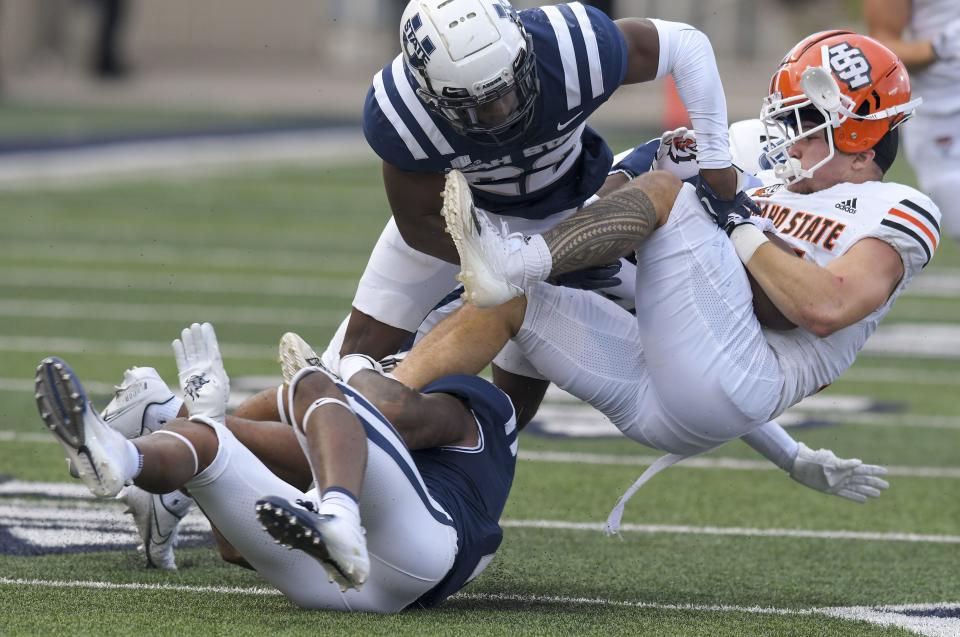 Utah State safety Anthony Switzer, left, and cornerback Michael Anyanwu (22) tackle Idaho State running back Keoua Kauhi (24) during the first half of an NCAA college football game Saturday, Sept. 9, 2023, in Logan, Utah. | Eli Lucero/The Herald Journal via AP