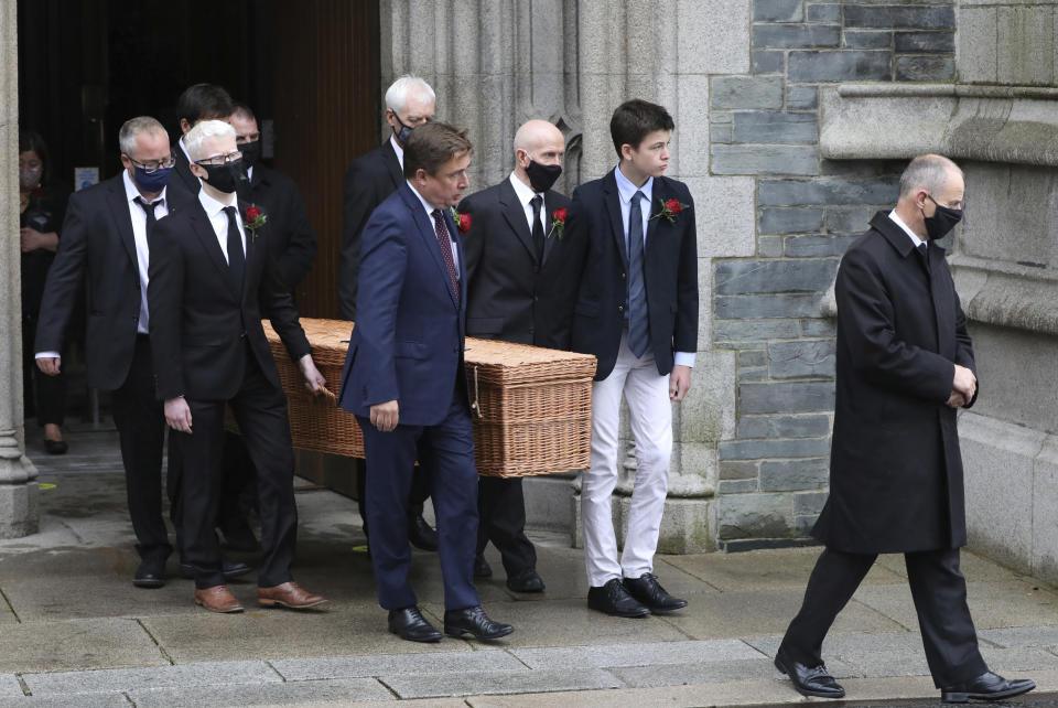 The coffin of the former Northern Ireland lawmaker and Nobel Peace Prize winner John Hume is carried from funeral Mass at St Eugene's Cathedral, pall bearers include his son John Hume, front center, with other family members in Londonderry, Northern Ireland, Wednesday, Aug. 5, 2020. Hume was co-recipient of the 1998 Nobel Peace Prize with fellow Northern Ireland lawmaker David Trimble, for his work in the Peace Process in Northern Ireland. Masks are worn due to the ongoing Coronavirus outbreak . (AP Photo/Peter Morrison)