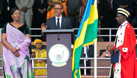 Rwanda's President-elect Paul Kagame (C) takes the oath of office as his wife Jeannette and Rwanda's Chief Justice Sam Rugege (R) look on during his swearing-in ceremony at Amahoro stadium in Kigali, Rwanda, August 18, 2017. REUTERS/Jean Bizimana