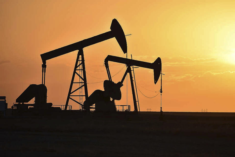 In this Wednesday, May 19, 2021, photo, pump jacks extract oil from beneath the ground on the Fort Berthold Indian Reservation east of New Town, North Dakota. On oil well pads carved from the wheat fields around Lake Sakakawea, hundreds of pump jacks slowly bob to extract 100 million barrels of crude annually from a reservation shared by three Native American tribes. (AP Photo/Matthew Brown)