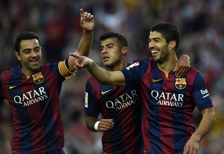 (R-L) Barcelona's Luis Suarez, Rafinha and Xavi Hernandez celebrate after scoring a goal during the Spanish league football match FC Barcelona vs Getafe at the Camp Nou stadium in Barcelona on April 28, 2015