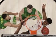 Wisconsin guard Khalil Iverson, right, shoots against Oregon forward Paul White, left, and guard Payton Pritchard during the first half of a first round men's college basketball game in the NCAA Tournament, Friday, March 22, 2019, in San Jose, Calif. (AP Photo/Ben Margot)