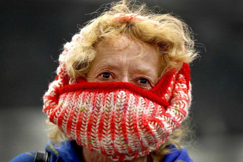 CZECH REPUBLIC: A woman covers her nose and mouth with a knitted scarf as she wait for a subway train in Prague.