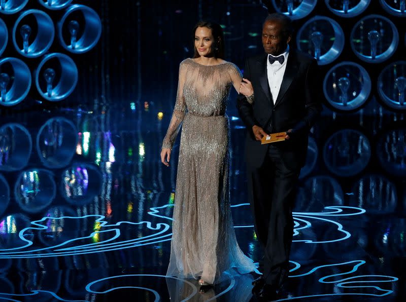 FILE PHOTO: Actors Jolie and Poitier take the stage to present the Oscar for achievement in directing at the 86th Academy Awards in Hollywood