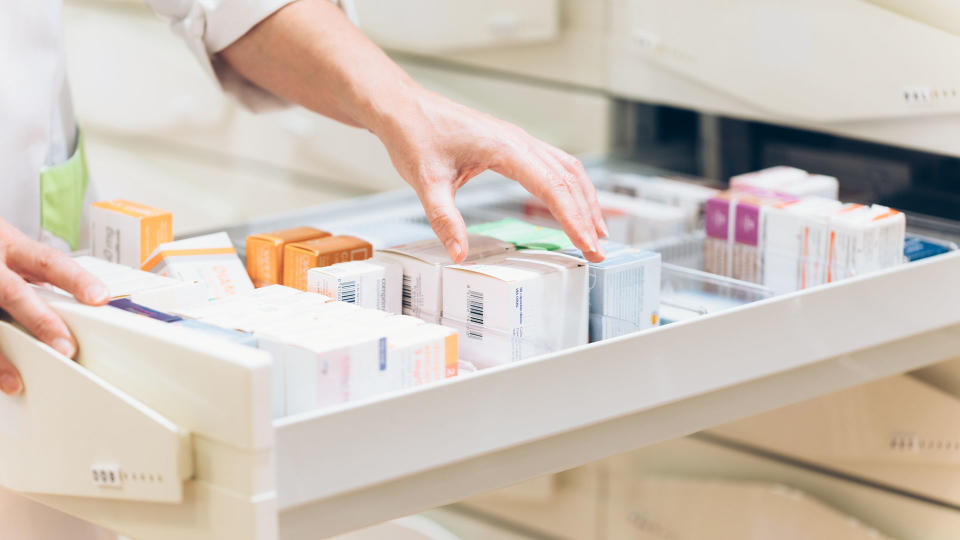 Pharmacist going through a draw of prescription drugs