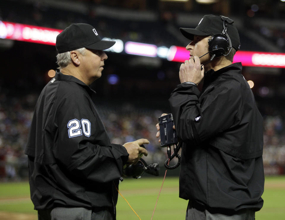 MLB umpires Pat Hoberg (20) and Chris Guccione review a play challenged by San Francisco Giants manager Bruce Bochy (15) in the fourth inning during a baseball game against the Arizona Diamondbacks, Tuesday, April 1, 2014, in Phoenix. (AP Photo/Rick Scuteri)