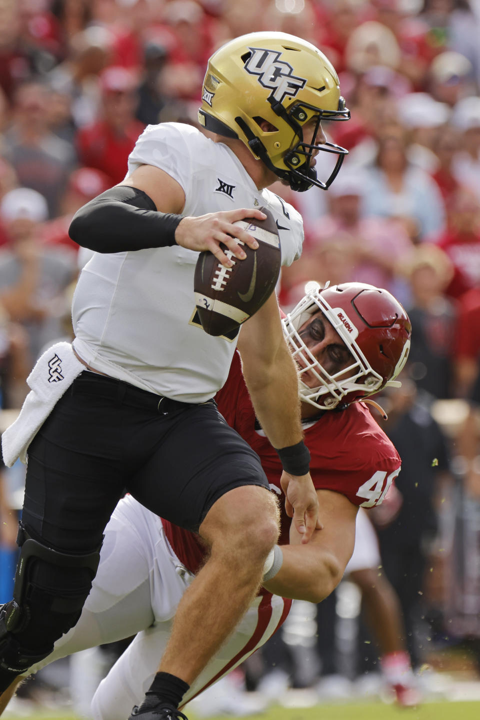 UCF quarterback John Rhys Plumlee runs away from Oklahoma defensive lineman Ethan Downs in the first half of an NCAA college football game, Saturday, Oct. 21, 2023, in Norman, Okla. (AP Photo/Nate Billings)