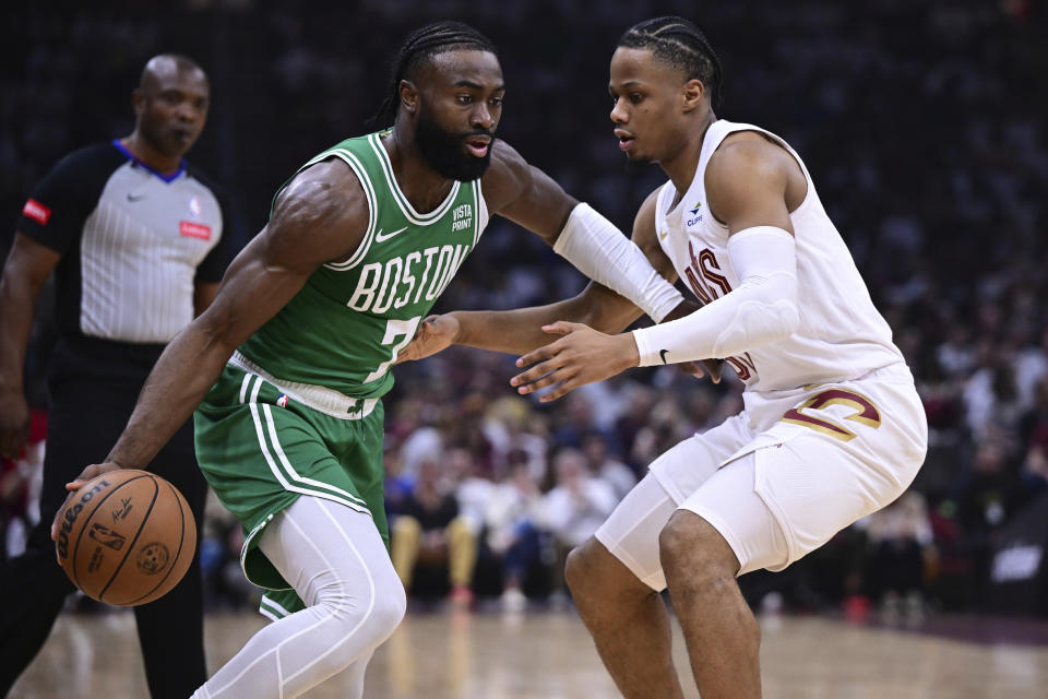 Boston Celtics guard Jaylen Brown (7) drives on Cleveland Cavaliers forward Isaac Okoro, right, during the first half of Game 4 of an NBA basketball second-round playoff series Monday, May 13, 2024, in Cleveland. (AP Photo/David Dermer)