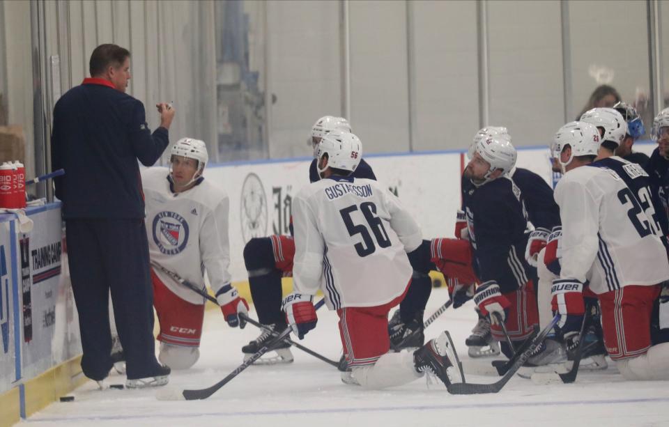 New York Rangers head coach Peter Laviolette, left, meets with the team during a training session at their facility in Tarrytown, Sept. 22, 2023.