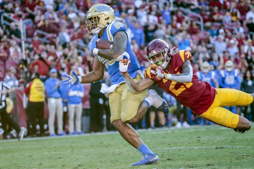 LOS ANGELES, CA, SATURDAY, NOVEMBER 23, 2019 - UCLA Bruins tight end Devin Asiasi (86) runs past USC Trojans safety Isaiah Pola-Mao (21) for a third quarter touchdown at the Coliseum. (Robert Gauthier/Los Angeles Times)