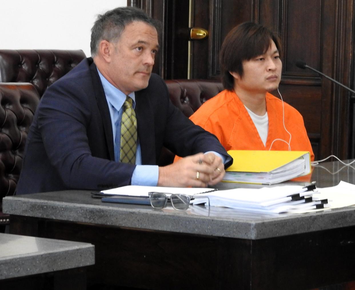 Attorney Thomas Kollin of Beavercreek with client Ming Xue Wednesday in Coshocton County Common Pleas Court. Xue entered guilty pleas to 299 counts of counterfeiting and and one count of engaging in a pattern of corrupt activity related to a scam to alter gift cards