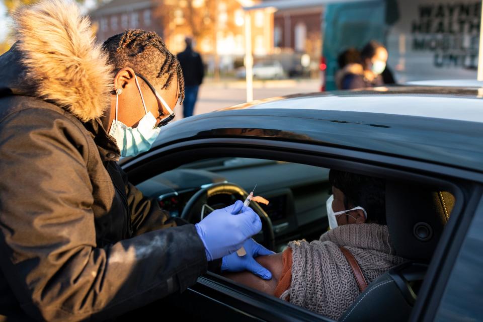 Jakiya West, Wayne Health's certified patient care technician and medical assistant administers a Covid-19 booster shot for April Rogers of Redford outside of Third New Hope Baptist Church in Detroit on Thursday, Nov. 4, 2021.