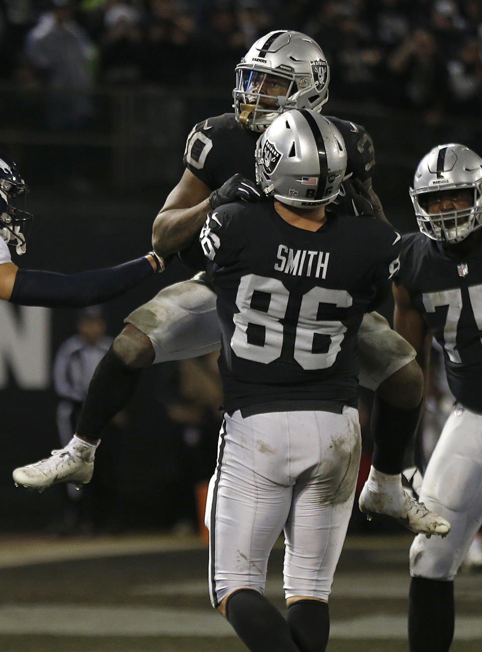 Oakland Raiders running back Jalen Richard, top, celebrates with tight end Lee Smith (86) after scoring against the Denver Broncos during the second half of an NFL football game in Oakland, Calif., Monday, Dec. 24, 2018. (AP Photo/D. Ross Cameron)