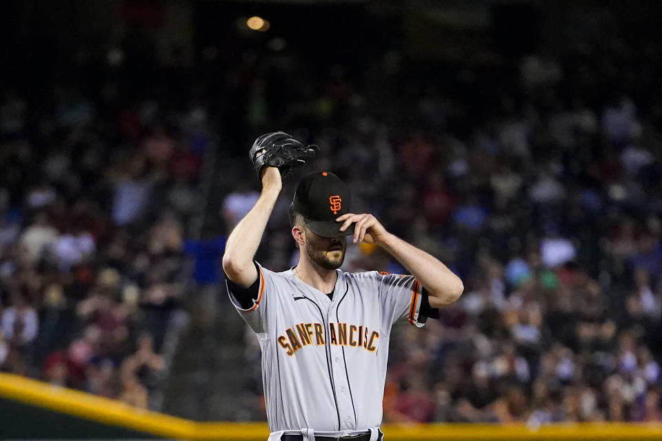 San Francisco Giants pitcher Alex Wood adjusts his cap after giving up a run against the Arizona Diamondbacks during the fourth inning of a baseball game, Tuesday, Sept. 19, 2023, in Phoenix. (AP Photo/Matt York)