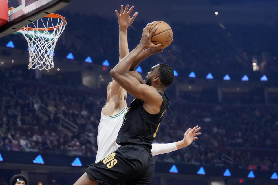 Cleveland Cavaliers forward Evan Mobley, right, shoots as Boston Celtics center Kristaps Porzingis, left, defends in the first half of an NBA basketball game, Tuesday, March 5, 2024, in Cleveland. (AP Photo/Sue Ogrocki)