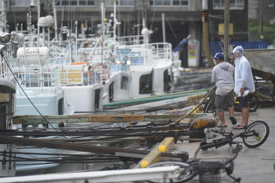 Fishermen make a routine check on their boat docked at the Tomari fishery port in Naha in the main Okinawa island, southern Japan, Thursday, June 1, 2023, after they have prepared some protections against a tropical storm nearing the Okinawa islands. (AP Photo/Hiro Komae)