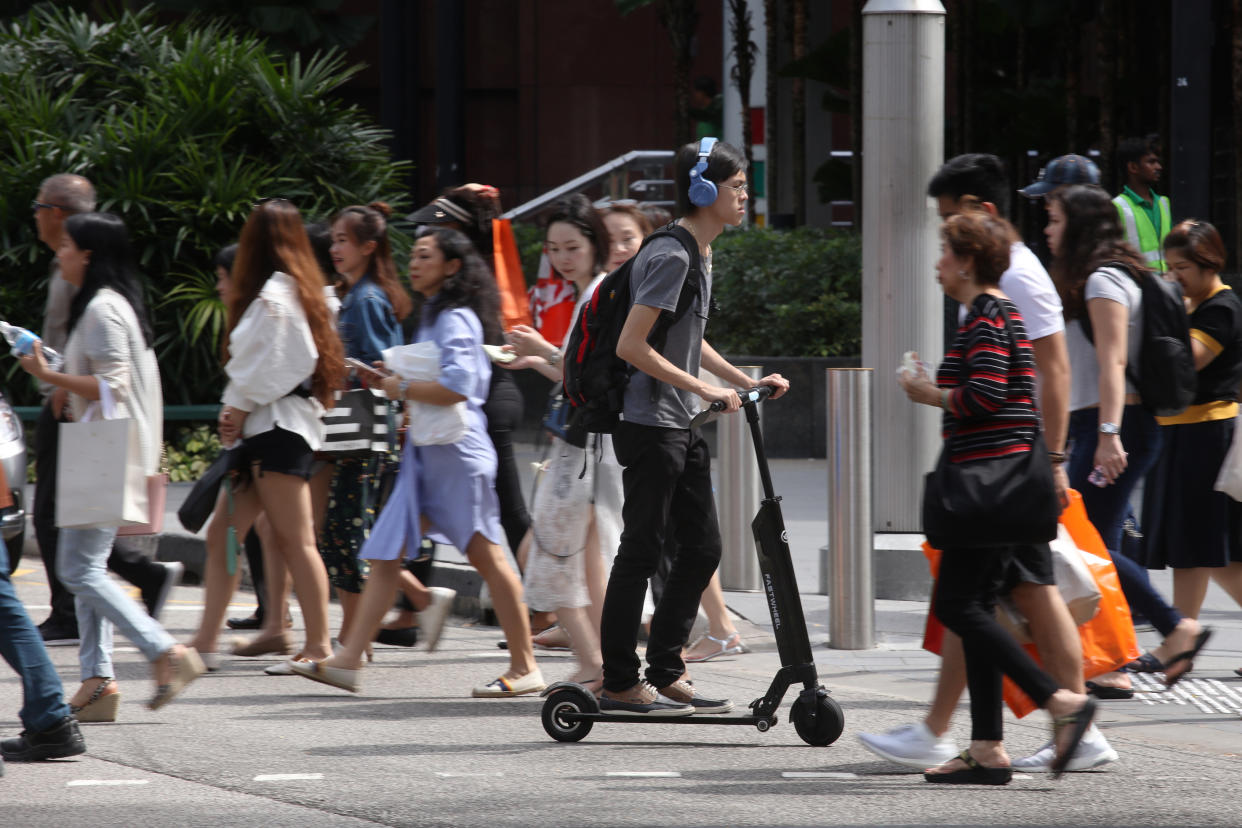 A man riding an e-scooter at a pedestrian crossing at Orchard Road. (FILE PHOTO: Yahoo News Singapore)