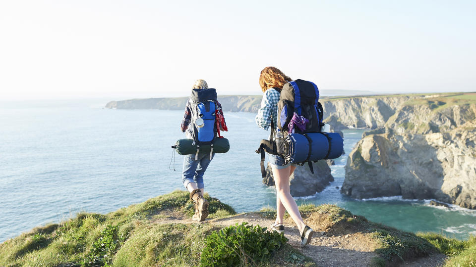 Two female hikers walk along a coastal path over looking the Atlantic Ocean