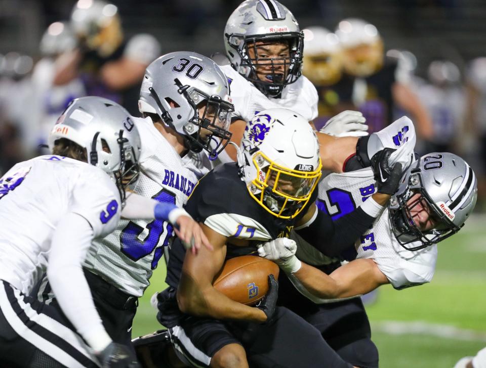 Gahanna’s Brayden Sanders (17) is tackled by Hilliard Bradley’s Andrew Miller (9), Nikolaj Kisin (30), Cameron Neely and Ethen Tebbetts (20) 
during a Division I regional quarterfinal Nov. 4 at Whitehall.