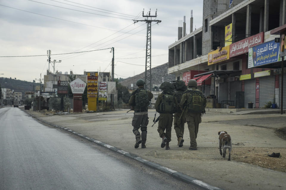Israeli soldiers on patrol in the flashpoint Palestinian town of Hawara, which has wholly emptied after the Israeli military closed shops and banned Palestinian vehicles from the main road in the wake of Palestinian militant attacks and settler violence in the town, Sunday, Nov. 12, 2023. With the world’s attention focused on the fighting in Gaza, Israeli settler violence against Palestinians since Oct. 7 has surged to the highest levels ever recorded by the United Nations. Palestinians say this Israel-Hamas war has left them more scared and vulnerable than ever in recent memory. (AP Photo/Mahmoud Illean)