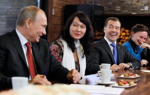 Russian President Dmitry Medvedev (2ndR) laughs with Prime Minister Vladimir Putin (L) during a meeting with 'Women's Forum' representatives at the Gorki residence outside Moscow on November 25. The upper house of Russia's parliament on Friday formally set March 4 as the date for the presidential election, a vote expected to see Putin return to the top job