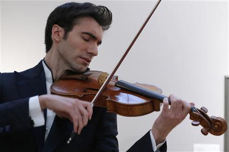 Violist David Aaron Carpenter of the U.S. plays the 'Macdonald' Viola by Antonio Stradivari, made in 1719, at Sotheby's gallery in New York March 27, 2014. REUTERS/Eduardo Munoz