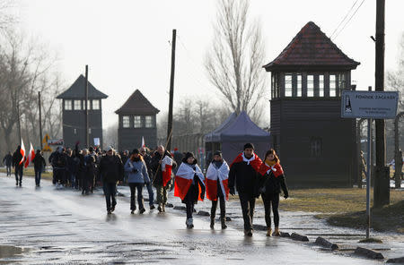 People walk along the fence of the former Nazi German concentration and extermination camp Birkenau, during the ceremonies marking the 74th anniversary of the liberation of the camp and International Holocaust Victims Remembrance Day, near Oswiecim, Poland, January 27, 2019. REUTERS/Kacper Pempel