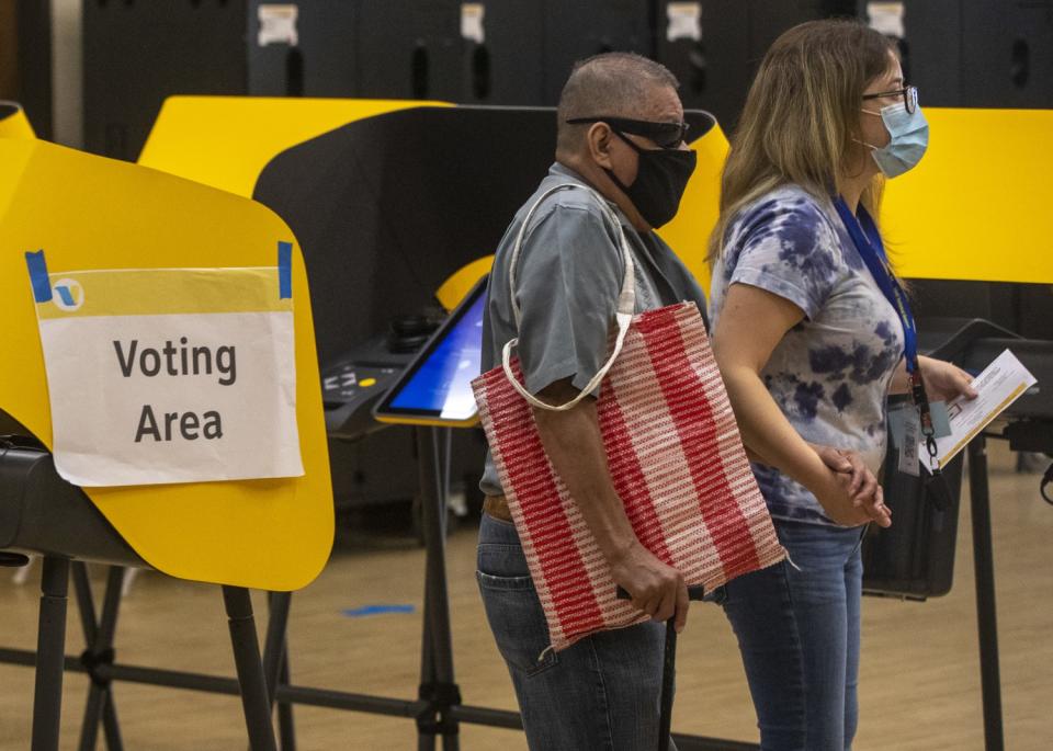 Two voters wearing masks