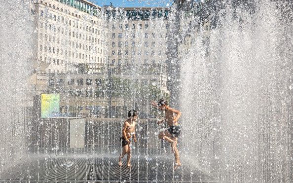 Children cool off in a fountain outside the Southbank Centre during a heatwave in London - Getty Images Europe