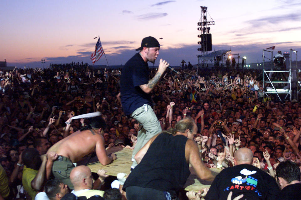 a performer on stage while fans climb on top