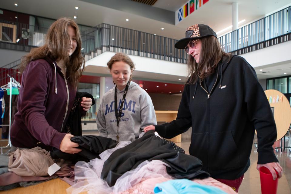 Devynn Rathe, left, Preslee Rathe and Crystal Rathe look Friday for a prom dress for Devynn during a prom dress giveaway at North Eugene High School.