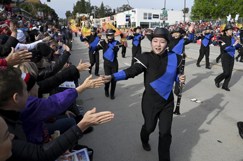 Integrantes de la banda All Gifu Honor Green de Japón saludan al público en el 134o Desfile de las Rosas en Pasadena, California, el lunes 2 de enero de 2023. (Foto AP/Michael Owen Baker)