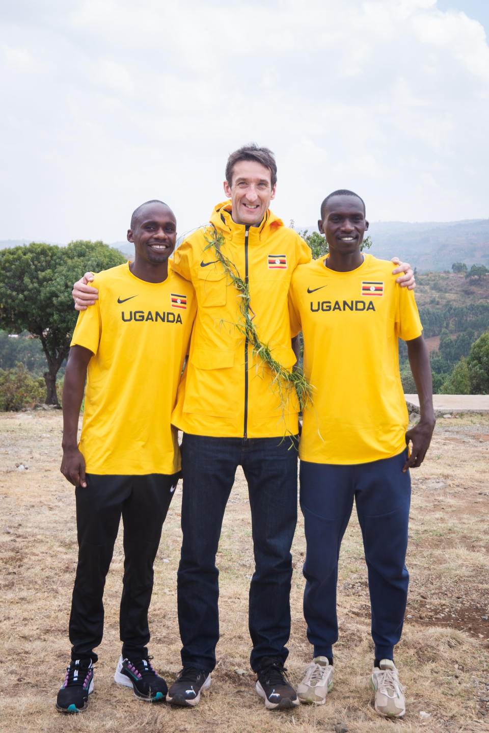 Rob Walker posing with Jacob Kiplimo (left) and Joshua Cheptegei (right)