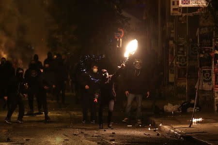 A hooded protester throws a petrol bomb during clashes following an anniversary rally marking the 2008 police shooting of 15-year-old student, Alexandros Grigoropoulos, in Athens, Greece, December 6, 2016. REUTERS/Alkis Konstantinidis