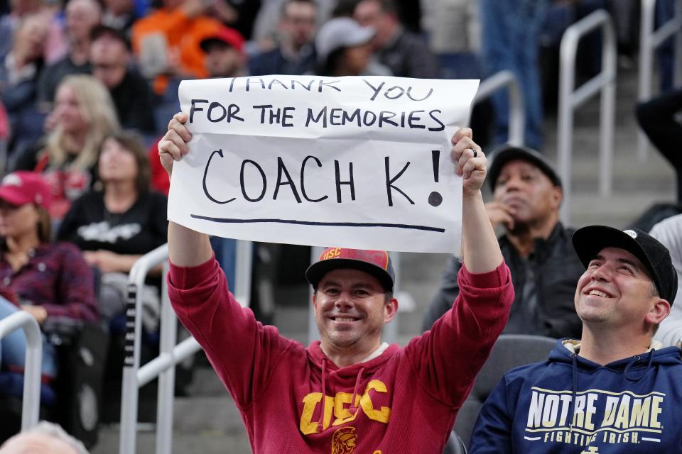 A fan wearing USC gear holds a sign paying tribute to Duke coach Mike Krzyzewski.