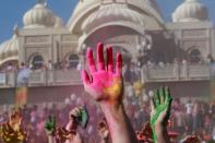 Revelers with colored corn starched hands celebrate during the 2014 Festival of Colors, Holi Celebration at the Krishna Temple Saturday, March 29, 2014, in Spanish Fork, Utah. Nearly 70,000 people are expected to gather starting Saturday at a Sri Sri Radha Krishna Temple in Spanish Fork for the annual two-day festival of colors. Revelers gyrate to music and partake in yoga during the all-day festival, throwing colored corn starch in the air once every hour. The Salt Lake Tribune reports that the large majority of participants are not Hindus, but Mormons. Thousands of students from nearby Brigham Young University come to take part in a festival that is drug and alcohol free. The event stems from a Hindu tradition celebrating the end of winter and the triumph of good over evil. (AP Photo/Rick Bowmer)