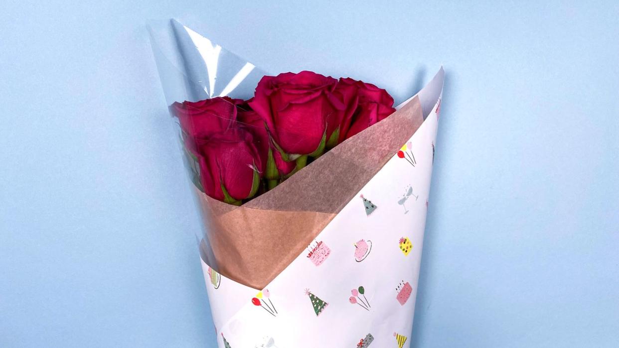 bouquet of roses wrapped in birthday wrapping paper