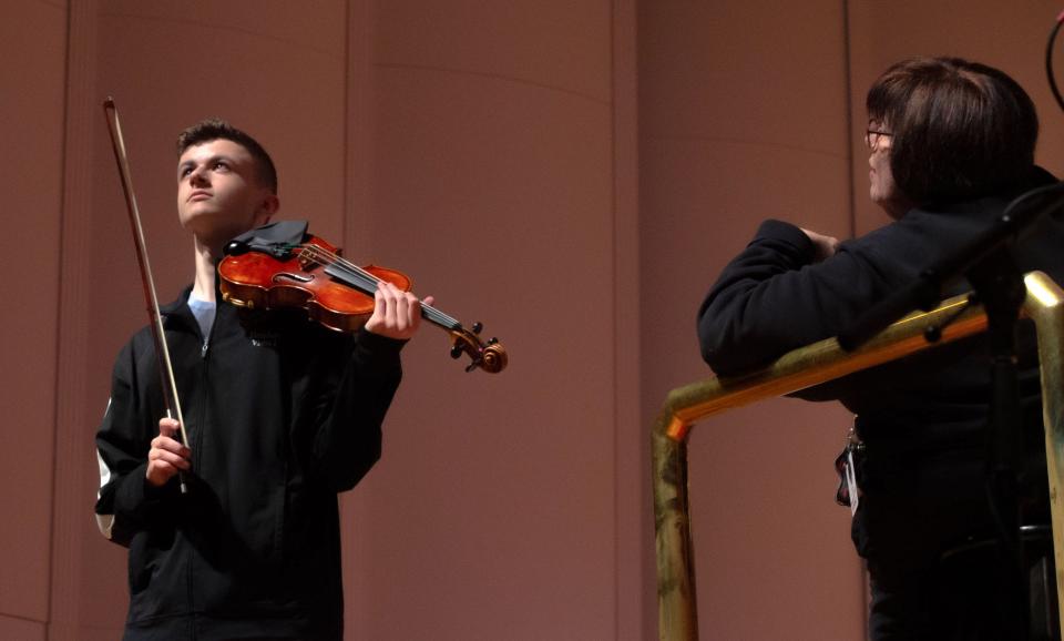 Braden Riley rehearses his solo piece on his violin during dress rehearsal the night before with the instruction of EVSC Youth Honors Orchestra conductor Sheryl Schuster, right, at Victory Theatre in Downtown Evansville on Wednesday, March 1, 2023.