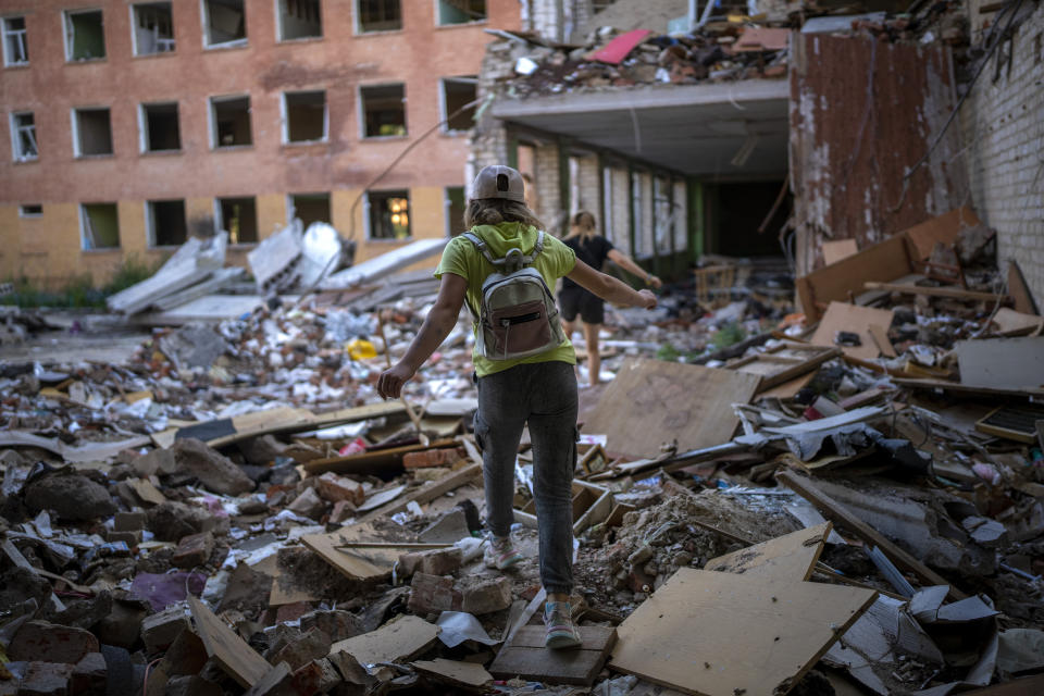 Student Karina Muzyka walks on the rubble of the Chernihiv School #21, which was bombed by Russian forces on the 3rd of March, in Chernihiv, Ukraine, Monday, Aug. 29, 2022. (AP Photo/Emilio Morenatti)