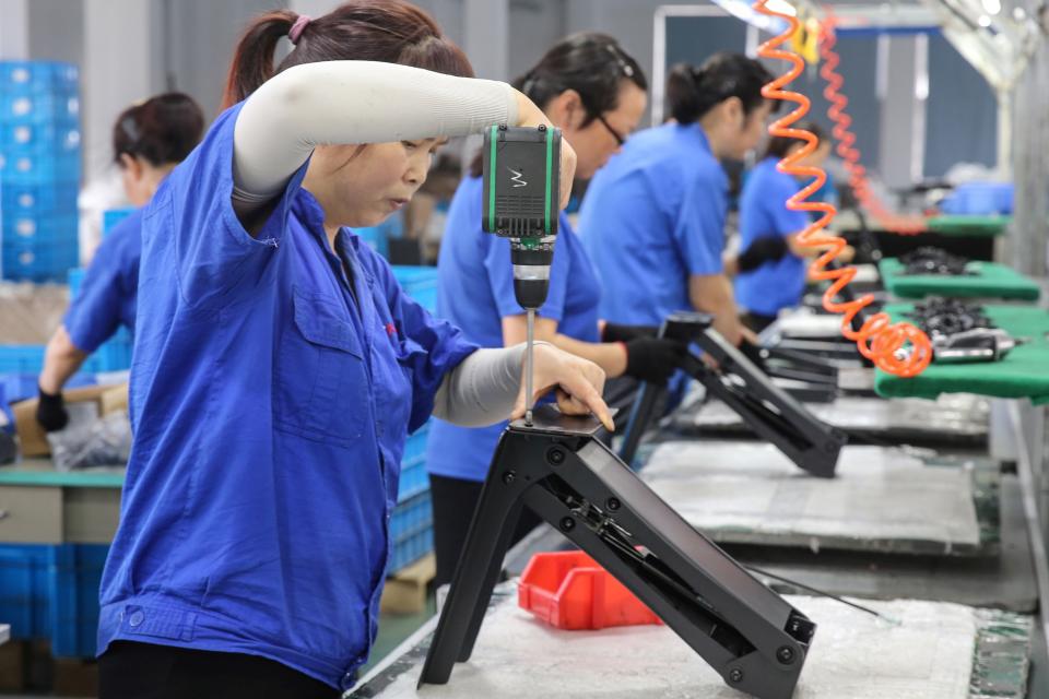 Los trabajadores producen escritorios para exportar a los EE. UU., Francia, Alemania y otros países, en una fábrica en Nantong, en la provincia oriental china de Jiangsu, el 4 de septiembre de 2019. Foto: STR / AFP / Getty Images.