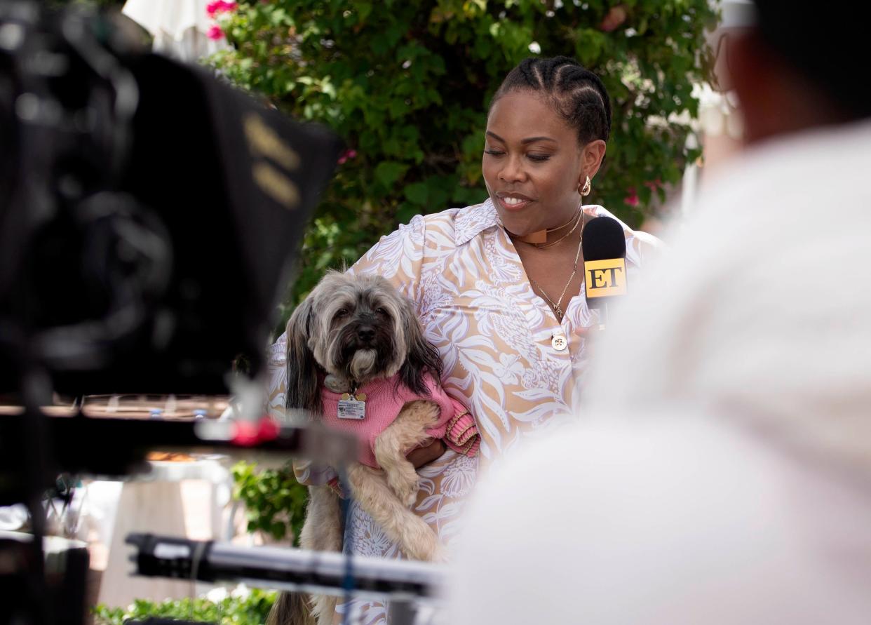 Amber Chardae Robinson of "Palm Royale" holds her dog Phoenix - Pheeny for short - during a taping of "Entertainment Tonight!" at The Colony on July 25, 2024 in Palm Beach.