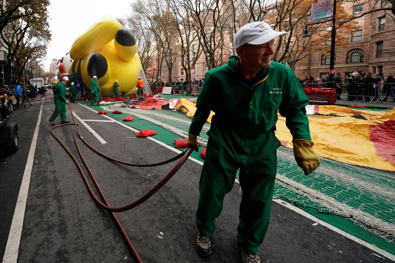 A member of the Macy's Thanksgiving Day Parade inflation team carries an inflation hose for balloons in New York