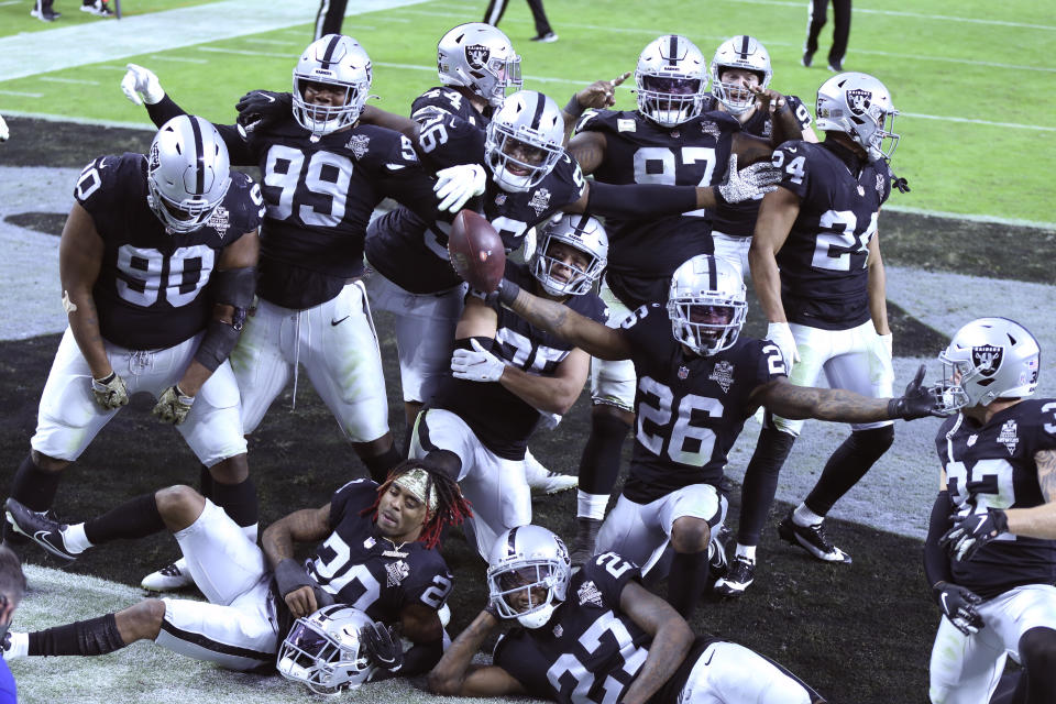 Las Vegas Raiders players celebrate a fumble recovery by Las Vegas Raiders cornerback Nevin Lawson (26) against the Denver Broncos during the second half of an NFL football game, Sunday, Nov. 15, 2020, in Las Vegas. (AP Photo/Isaac Brekken)