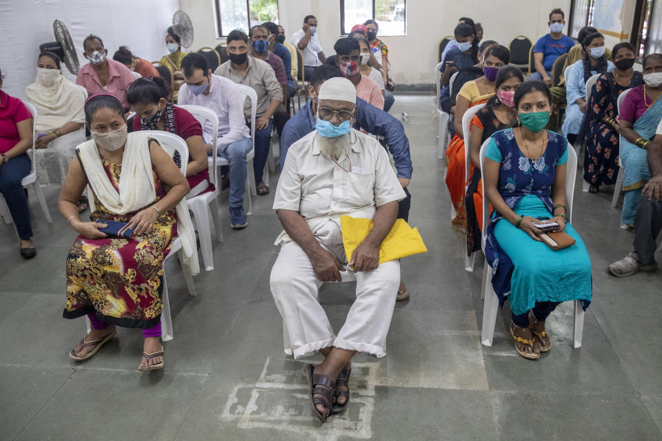 People wait to receive COVID-19 vaccine at a vaccination center in Mumbai, India, Thursday, Sept. 23, 2021. (AP Photo/Rafiq Maqbool)