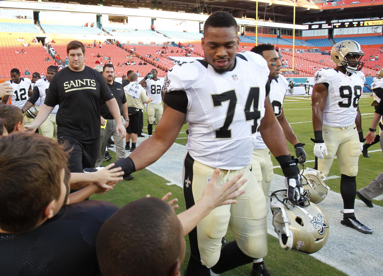 New Orleans Saints defensive end Glenn Foster (74) greets fans after practice before an NFL preseason football game against the Miami Dolphins, Thursday, Aug. 29, 2013 in Miami Gardens, Fla. (AP Photo/Wilfredo Lee)