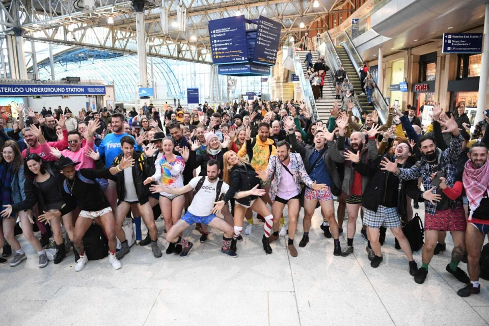 People pose as they take part in the annual 'No Trousers On The Tube Day' at Waterloo Station (AFP via Getty Images)