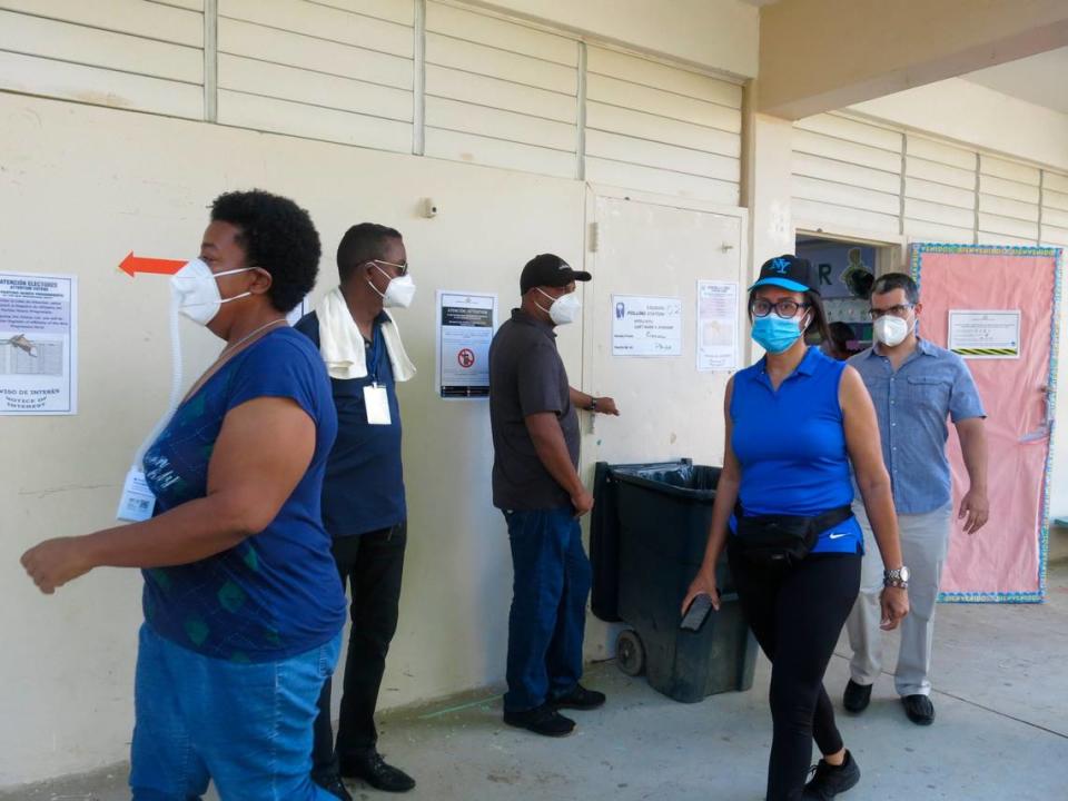 Voters leave a classroom with the required face masks after casting their ballots as volunteers look on in LoÃ­za, Puerto Rico, Sunday, Aug. 16, 2020. Thousands of Puerto Ricans on Sunday got a second chance to vote for the first time, a week after delayed and missing ballots marred the original primaries in a blow to the U.S. territory’s democracy. 