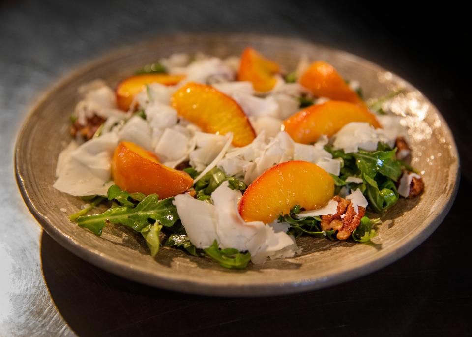 Warm peach and arugula salad filled with candied pecans, aged Spanish goat cheese and sherry vinegar at Oceano Kitchen in Lantana, June 29, 2017.